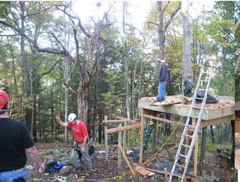 A treehouse platform being built in a wooded setting